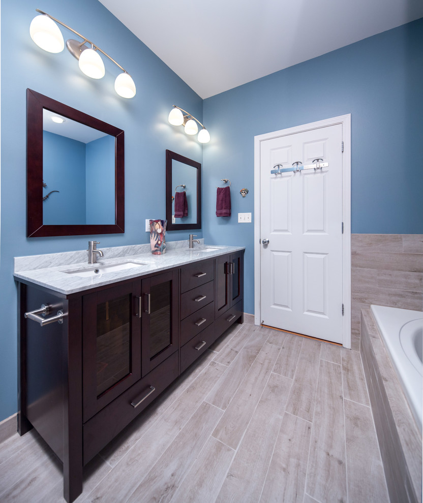 Mid-sized modern master bathroom in Chicago with shaker cabinets, dark wood cabinets, an alcove tub, an alcove shower, a two-piece toilet, brown tile, ceramic tile, blue walls, ceramic floors, an undermount sink and marble benchtops.