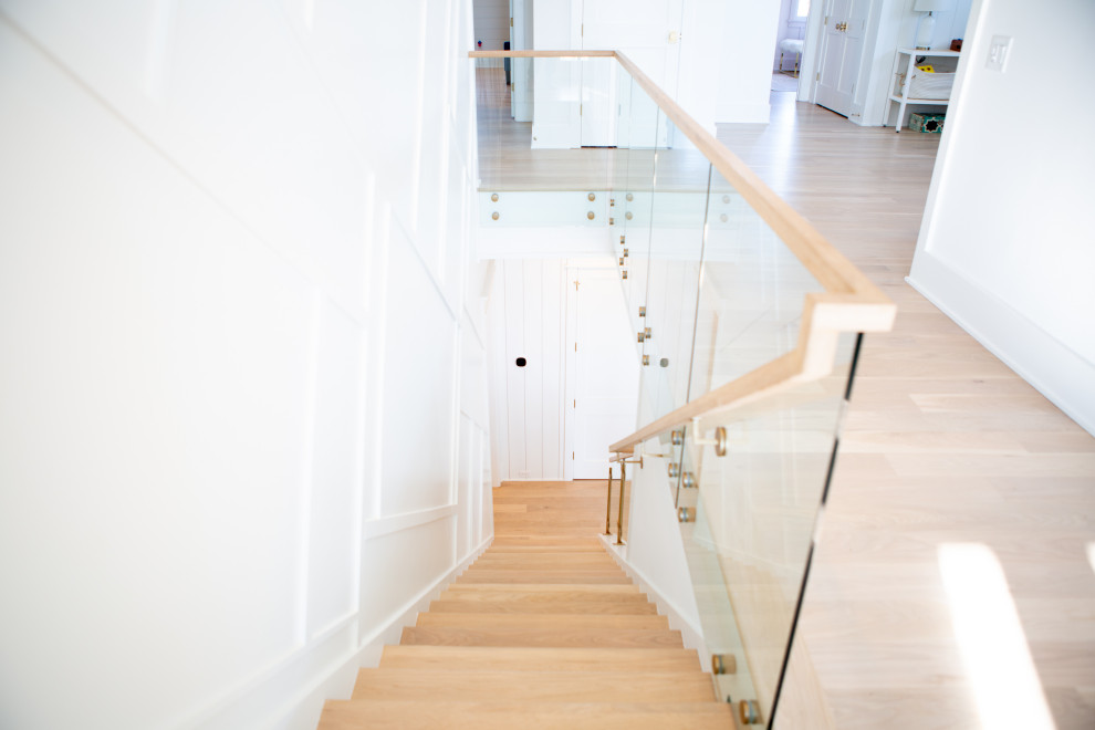 Источник вдохновения для домашнего уюта: большая прямая деревянная лестница в морском стиле с деревянными ступенями, стеклянными перилами и стенами из вагонки
