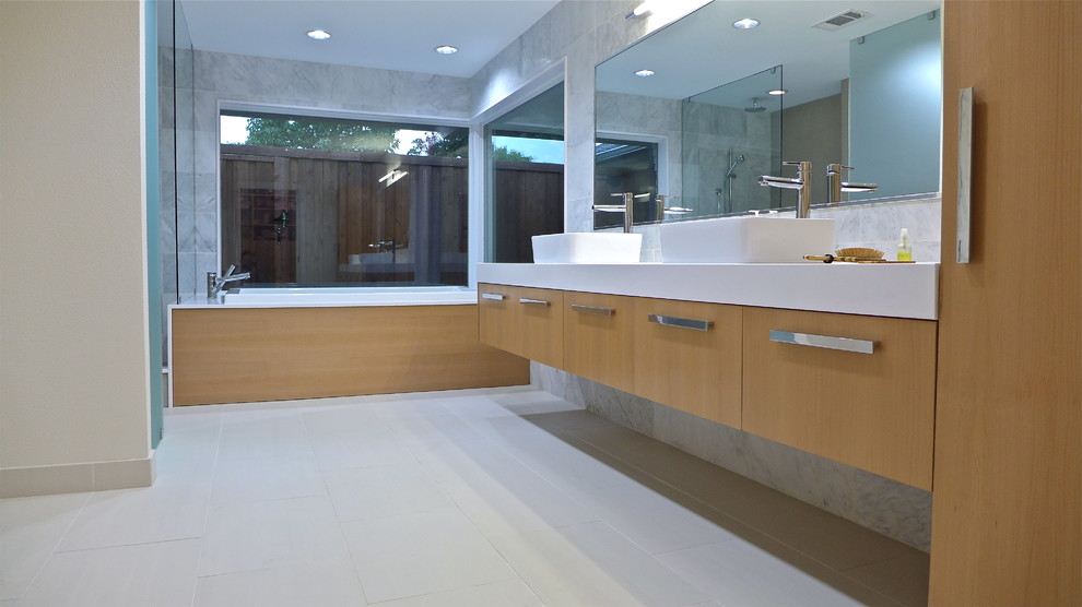 Photo of a large contemporary master bathroom in Dallas with a vessel sink, furniture-like cabinets, light wood cabinets, engineered quartz benchtops, a drop-in tub, an open shower, a two-piece toilet, blue tile, stone tile, white walls and porcelain floors.