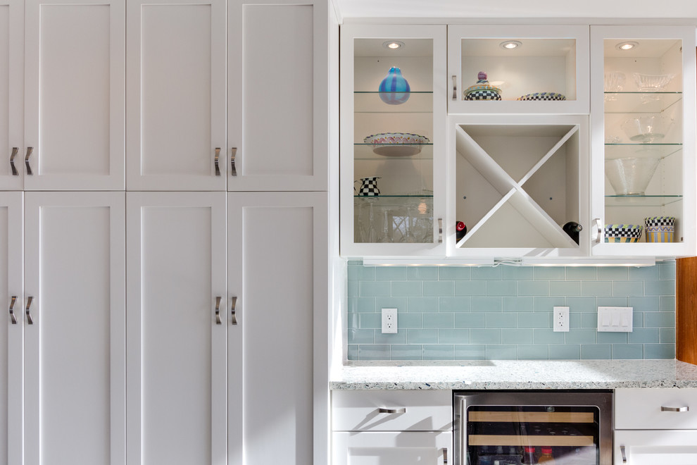 Inspiration for a transitional u-shaped eat-in kitchen in DC Metro with a farmhouse sink, shaker cabinets, white cabinets, quartz benchtops, blue splashback, subway tile splashback and stainless steel appliances.