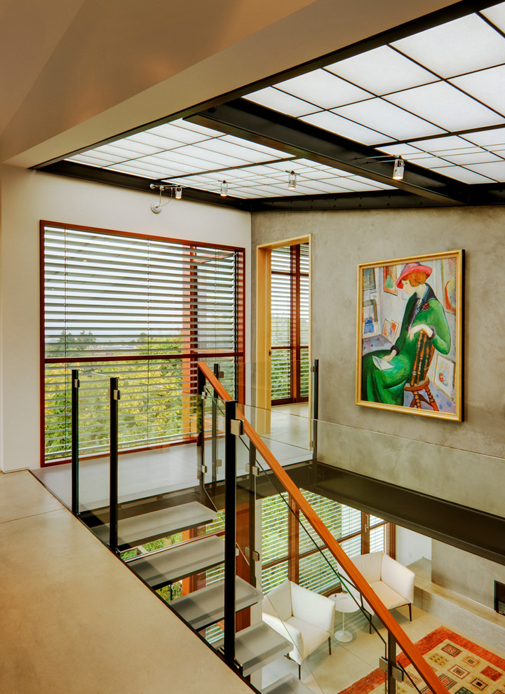 This is an example of a contemporary glass staircase in Seattle with open risers.