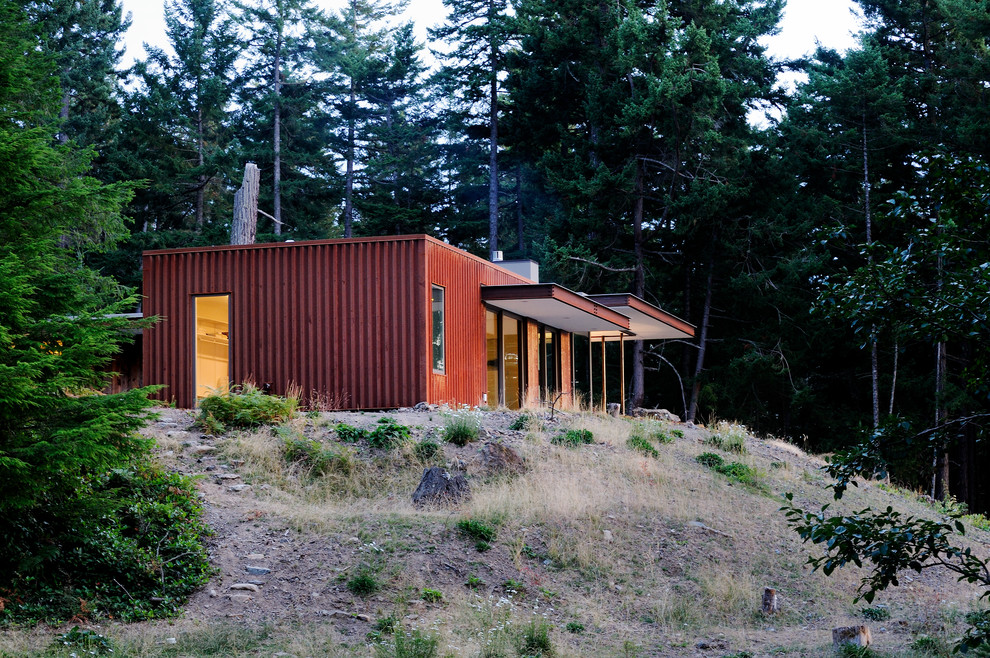 Inspiration for a mid-sized contemporary one-storey red exterior in Seattle with concrete fiberboard siding and a flat roof.