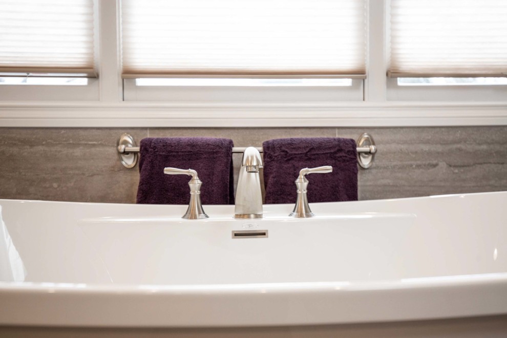 Large transitional master brown tile, beige tile and porcelain tile porcelain tile and beige floor freestanding bathtub photo in Chicago with raised-panel cabinets, white cabinets, beige walls, an undermount sink, granite countertops, a hinged shower door and beige countertops