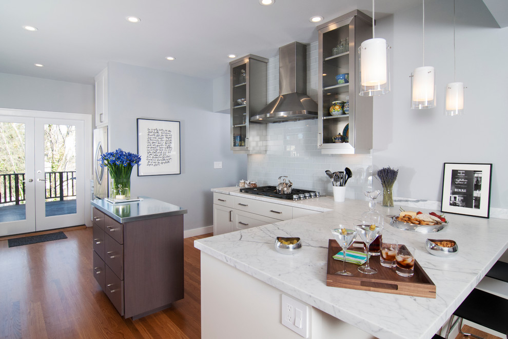 This is an example of a contemporary kitchen in San Francisco with flat-panel cabinets, white cabinets, white splashback, subway tile splashback and stainless steel appliances.