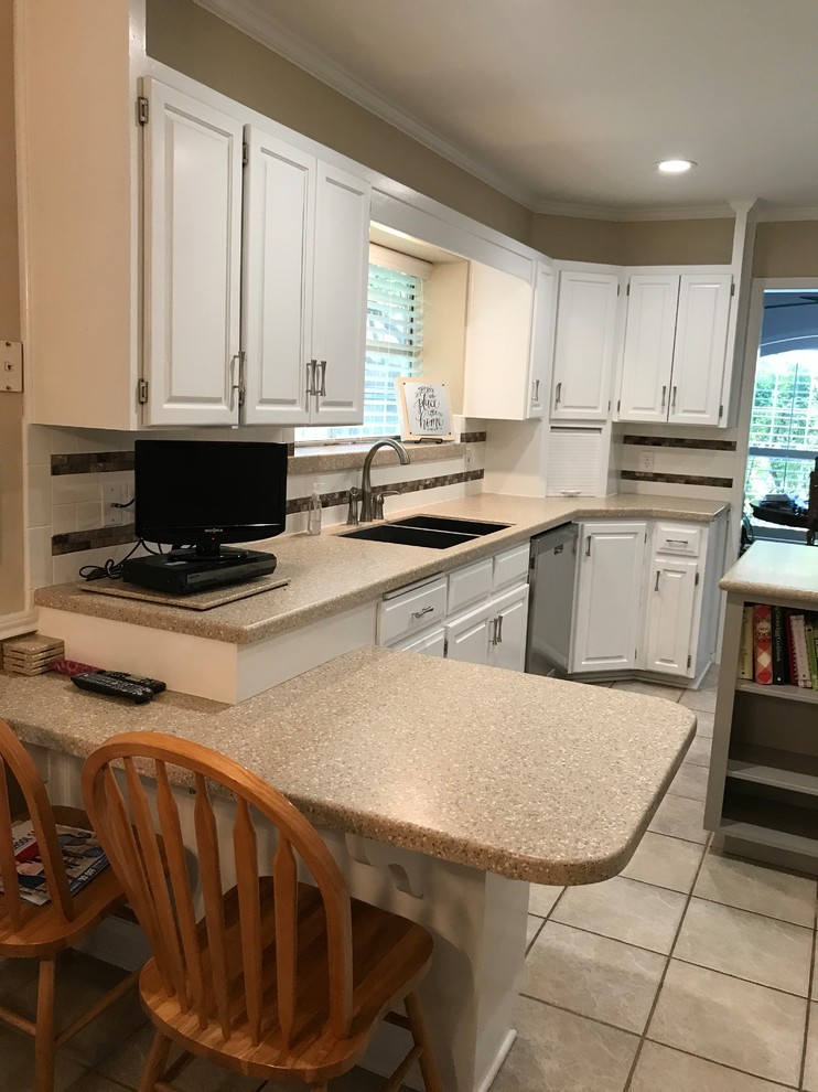 Inspiration for a mid-sized transitional l-shaped porcelain tile and beige floor enclosed kitchen remodel in Austin with a double-bowl sink, raised-panel cabinets, white cabinets, solid surface countertops, multicolored backsplash, mosaic tile backsplash, stainless steel appliances and an island