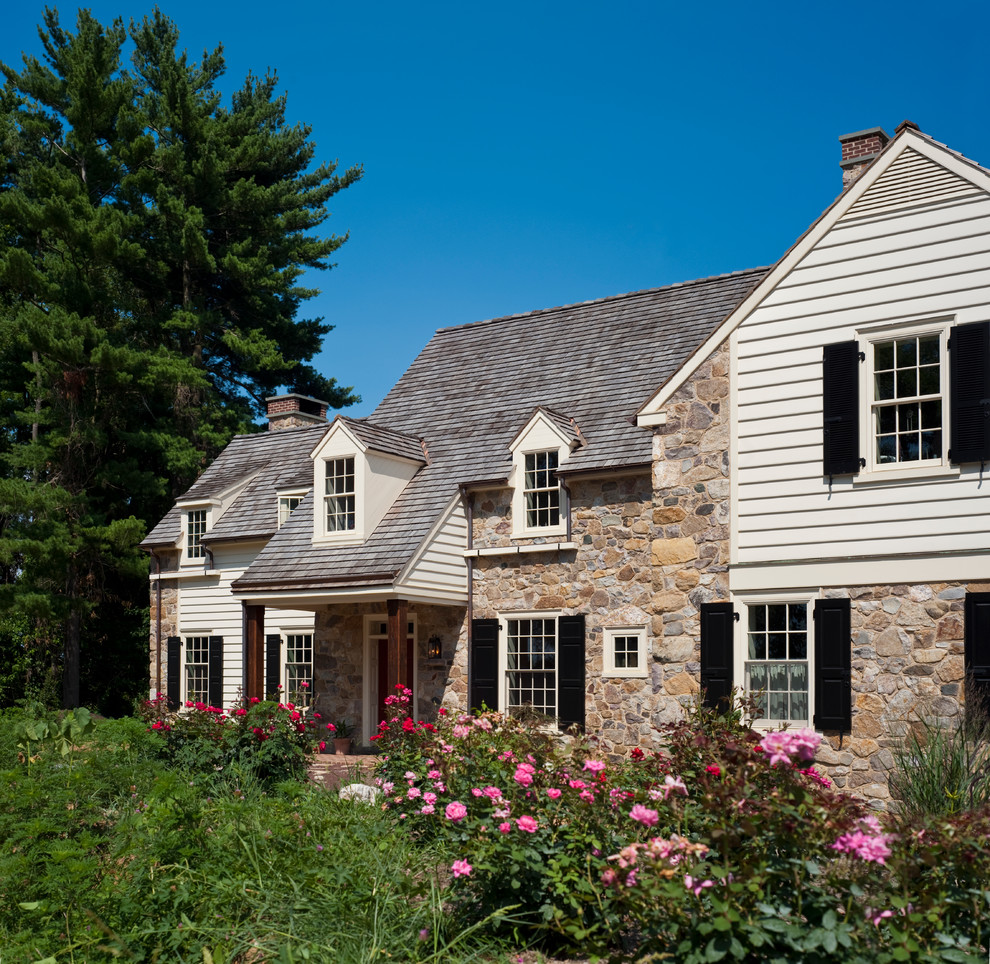 Design ideas for a traditional two-storey exterior in Philadelphia with stone veneer and a gable roof.
