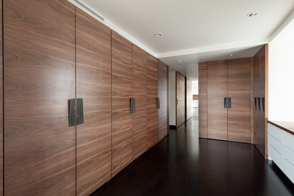 Photo of a large modern storage and wardrobe in Boston with flat-panel cabinets and dark hardwood floors.