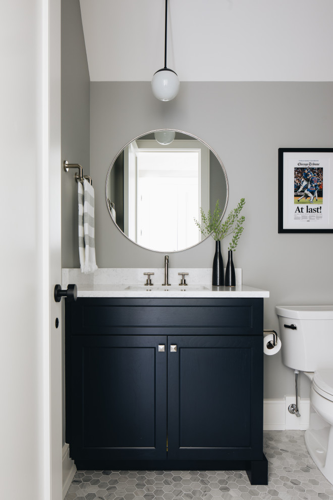 Modelo de cuarto de baño único y a medida actual de tamaño medio con puertas de armario azules, sanitario de una pieza, paredes grises, suelo con mosaicos de baldosas, suelo gris y encimeras blancas