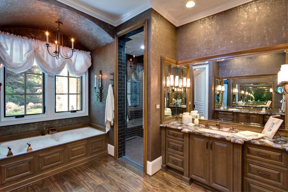 Large traditional master bathroom in Orange County with raised-panel cabinets, dark wood cabinets, an alcove tub, a curbless shower, brown tile, ceramic tile, brown walls, dark hardwood floors, an undermount sink, quartzite benchtops, a two-piece toilet, brown floor, a hinged shower door and multi-coloured benchtops.