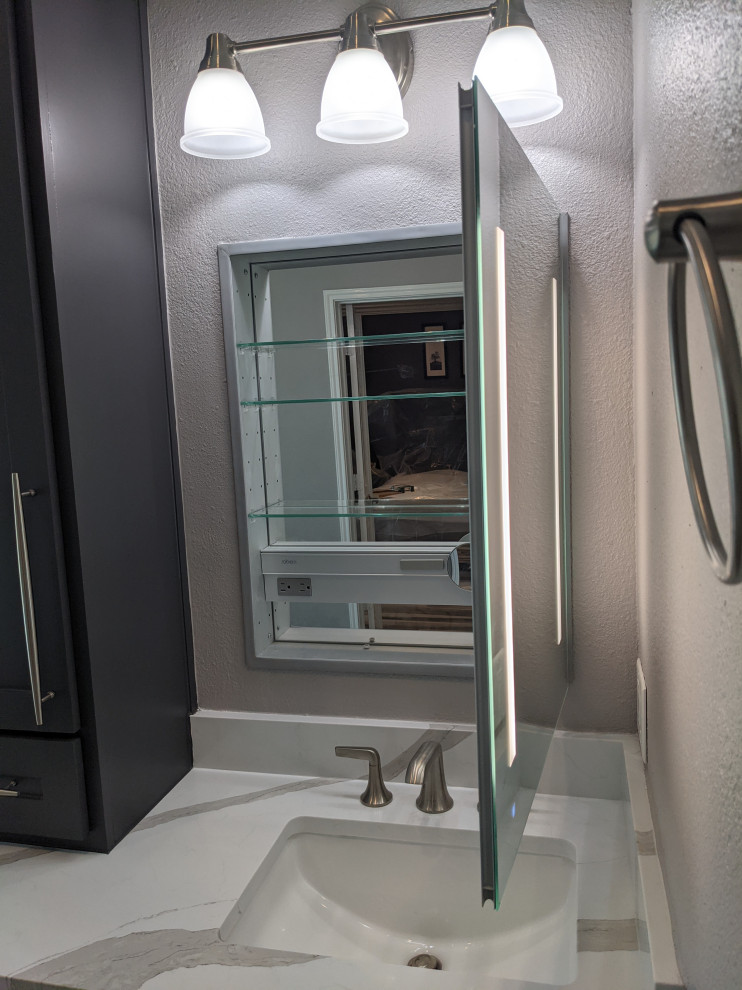 This is an example of a contemporary master bathroom in Houston with shaker cabinets, grey cabinets, a freestanding tub, a corner shower, a one-piece toilet, white tile, porcelain tile, wood-look tile, an undermount sink, engineered quartz benchtops, a hinged shower door, white benchtops, a niche, a double vanity and a built-in vanity.