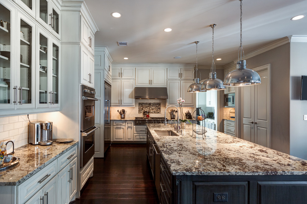 Design ideas for a large transitional l-shaped eat-in kitchen in Houston with granite benchtops, an undermount sink, raised-panel cabinets, white cabinets, white splashback, ceramic splashback, stainless steel appliances, dark hardwood floors and with island.