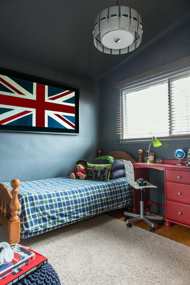 Boys Bedroom Design - This boys bedroom decor was inspired by the framed Union Jack flag, which also has sentimental value as the boy was born in London, UK.  We chose to paint the room entirely in Benjamin Moore's flint, including ceiling and trim.  The room is small but with the slanted ceilings and contrary to myth, the dark colour doesn't make this room feel smaller.  We popped with red and green accents and used many of the boys items as accessories when styling.