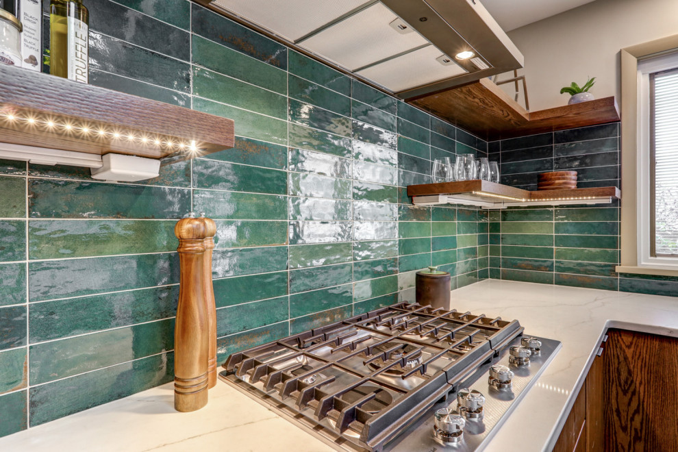 Photo of a large midcentury u-shaped kitchen/diner in Other with a submerged sink, flat-panel cabinets, dark wood cabinets, engineered stone countertops, green splashback, ceramic splashback, stainless steel appliances, cork flooring, an island, brown floors and white worktops.
