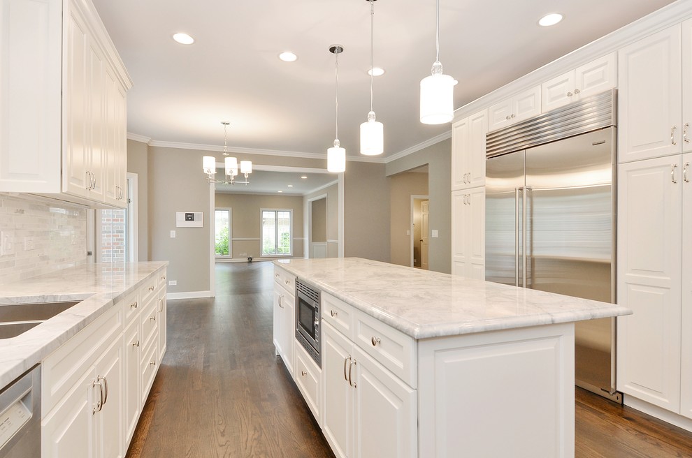 Transitional dark wood floor eat-in kitchen photo in Chicago with a drop-in sink, raised-panel cabinets, white cabinets, marble countertops, gray backsplash, ceramic backsplash, stainless steel appliances and an island