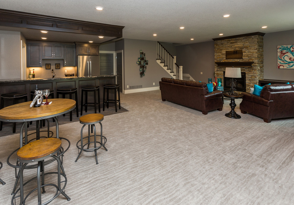 Basement - transitional walk-out carpeted basement idea with gray walls and a stone fireplace