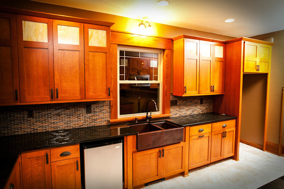 Photo of a large traditional u-shaped separate kitchen in Other with shaker cabinets, granite benchtops, a farmhouse sink, medium wood cabinets, stainless steel appliances and no island.