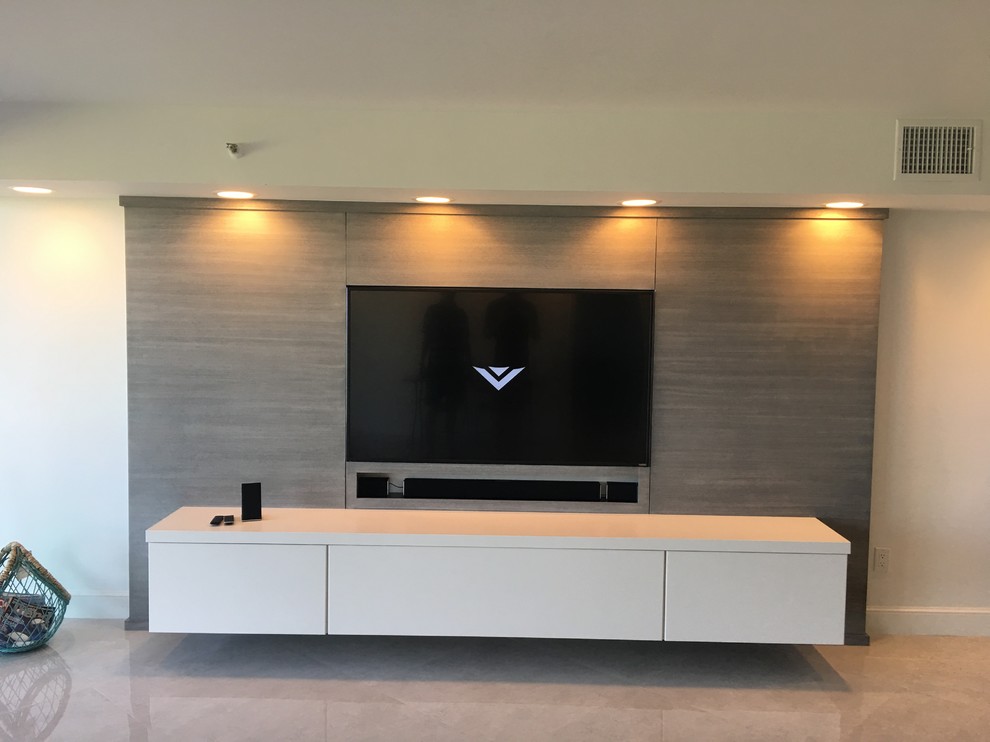 This is an example of a large contemporary enclosed home theatre in Miami with white walls, marble floors and a built-in media wall.