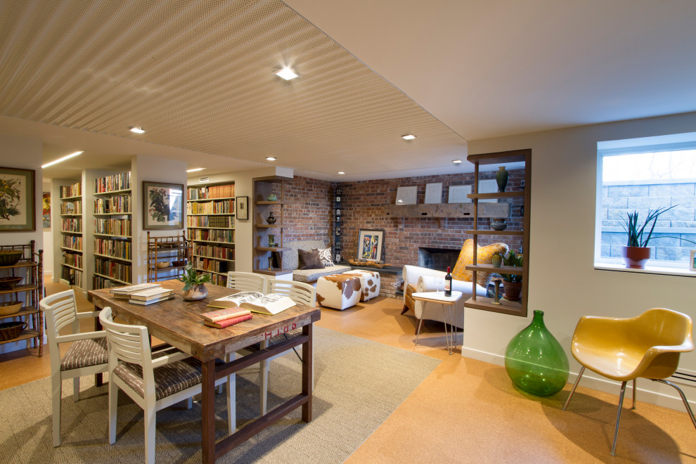 Mid-sized midcentury home office in New York with a library, white walls, cork floors, a standard fireplace, a brick fireplace surround, a freestanding desk, brown floor, coffered and brick walls.
