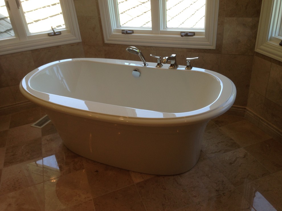 Inspiration for a large transitional master beige tile and stone tile marble floor freestanding bathtub remodel in Chicago with raised-panel cabinets, medium tone wood cabinets, quartz countertops, a two-piece toilet, an undermount sink and beige walls