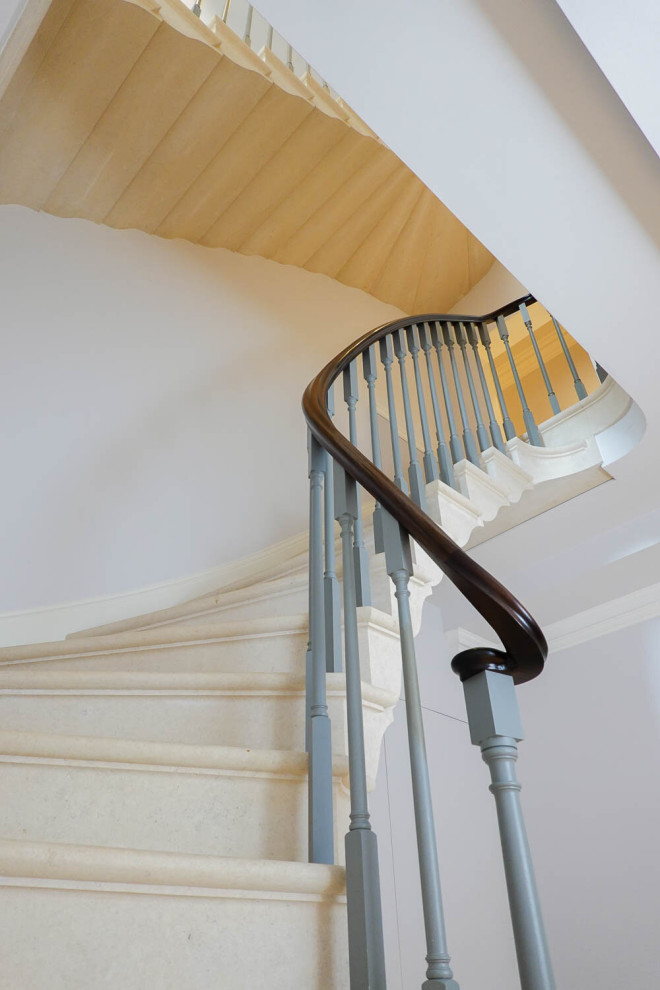 Imagen de escalera curva tradicional con escalones de piedra caliza, contrahuellas de piedra caliza y barandilla de madera