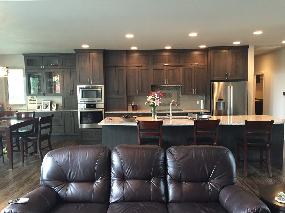 Mid-sized transitional galley dark wood floor open concept kitchen photo in Seattle with an undermount sink, shaker cabinets, dark wood cabinets, beige backsplash, mosaic tile backsplash, stainless steel appliances, an island and granite countertops