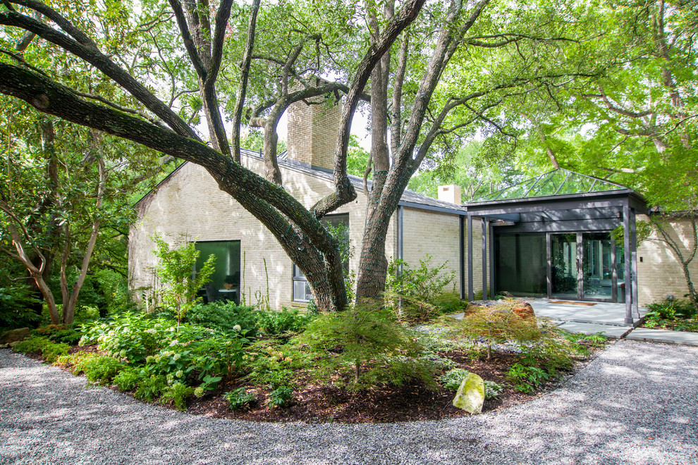 This is an example of a large contemporary shade front yard stone formal garden in Dallas.