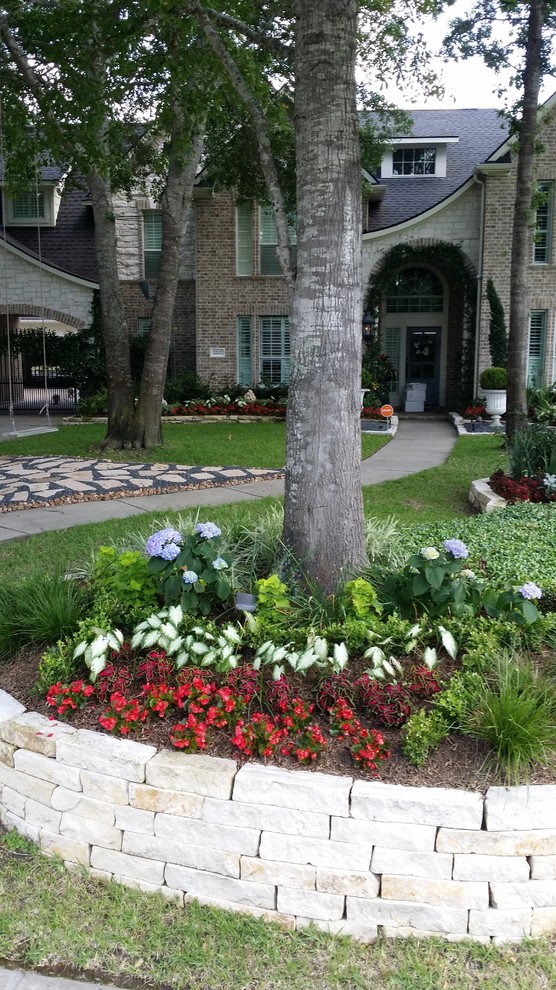 Photo of a large traditional front yard shaded garden for summer in Houston with brick pavers.