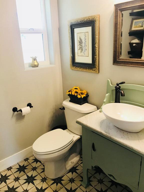 Idéer för att renovera ett mellanstort lantligt vit vitt badrum med dusch, med släta luckor, gröna skåp, en dusch i en alkov, en toalettstol med hel cisternkåpa, gul kakel, keramikplattor, grå väggar, klinkergolv i porslin, ett fristående handfat, marmorbänkskiva, flerfärgat golv och dusch med duschdraperi
