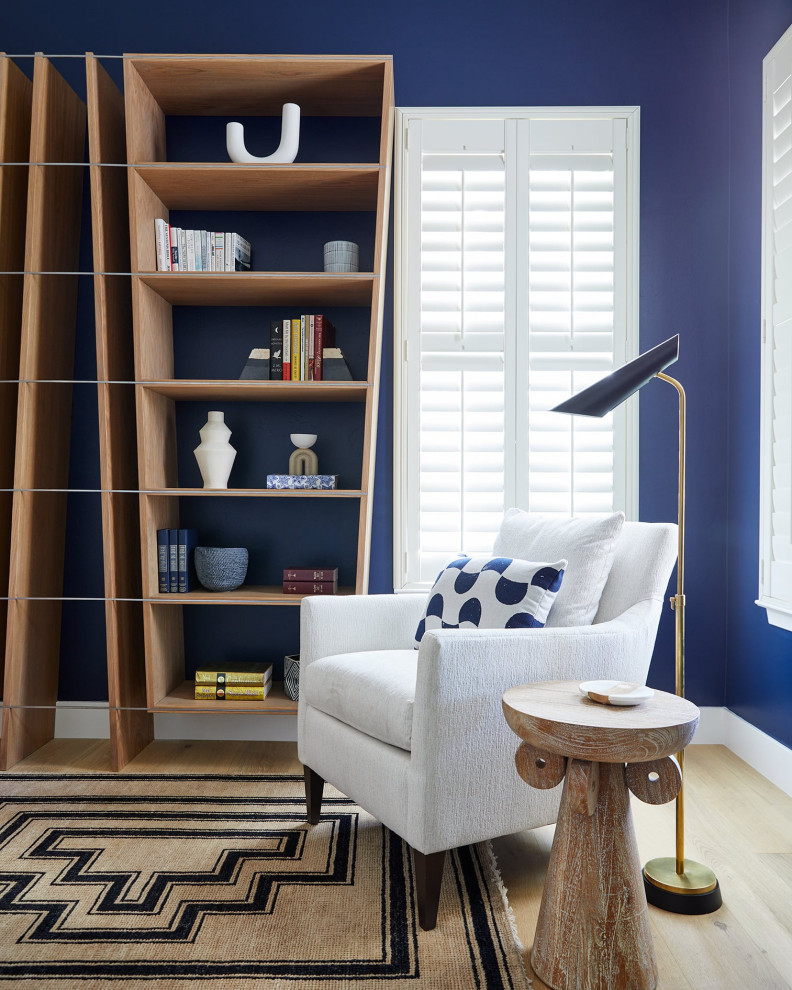 Idee per un soggiorno design di medie dimensioni e chiuso con libreria, pareti blu, parquet chiaro, nessuna TV e pavimento beige