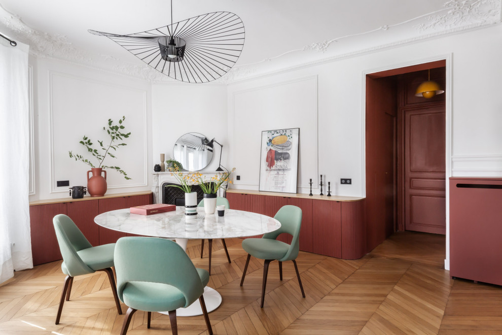Inspiration for a mid-sized contemporary open plan dining in Paris with light hardwood floors, a corner fireplace and decorative wall panelling.