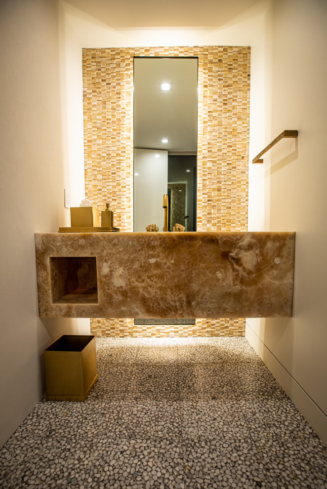 Ispirazione per un bagno di servizio contemporaneo di medie dimensioni con top in marmo, mobile bagno sospeso e pavimento con piastrelle di ciottoli