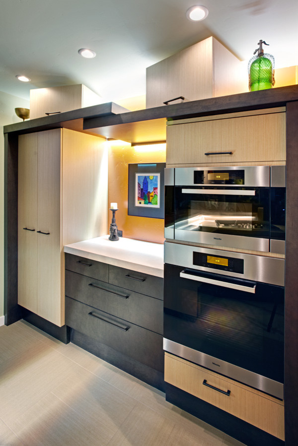 Photo of a mid-sized contemporary galley eat-in kitchen in Sacramento with an undermount sink, flat-panel cabinets, brown cabinets, solid surface benchtops, stainless steel appliances, porcelain floors and with island.