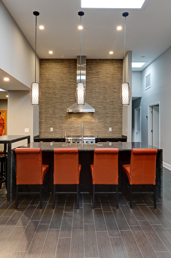 Large transitional u-shaped cement tile floor and brown floor open concept kitchen photo in Jacksonville with a drop-in sink, flat-panel cabinets, black cabinets, granite countertops, multicolored backsplash, stone tile backsplash, stainless steel appliances and an island