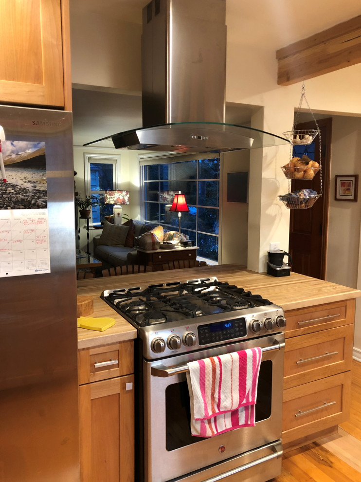 Mid-sized transitional galley eat-in kitchen in Seattle with an undermount sink, shaker cabinets, medium wood cabinets, quartz benchtops, white splashback, subway tile splashback, stainless steel appliances, medium hardwood floors, a peninsula, brown floor, grey benchtop and exposed beam.