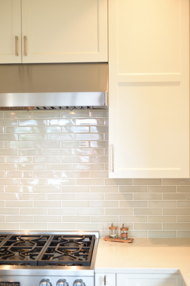 Inspiration for a transitional ceramic tile kitchen remodel in Seattle with shaker cabinets, white cabinets, quartzite countertops, subway tile backsplash, stainless steel appliances, an island and white countertops