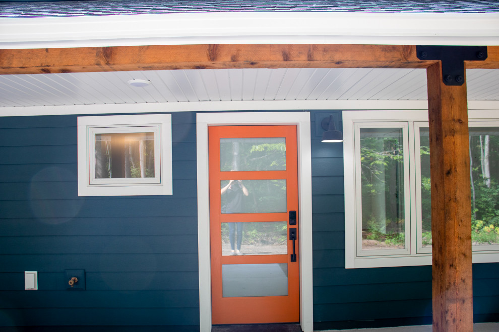 Стильный дизайн: прихожая среднего размера в стиле модернизм с синими стенами, бетонным полом, оранжевой входной дверью и бежевым полом - последний тренд