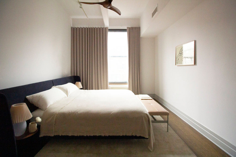 Mittelgroßes Industrial Schlafzimmer im Loft-Style mit grauer Wandfarbe, braunem Holzboden, braunem Boden und freigelegten Dachbalken in New York