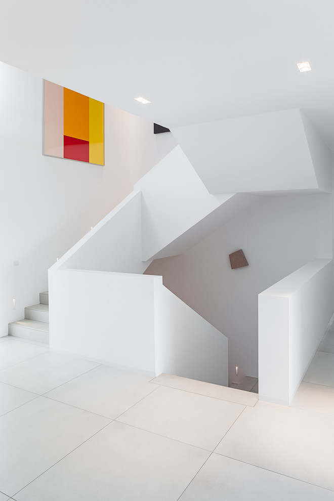 Photo of an expansive contemporary tile u-shaped staircase in Cologne with tile risers.