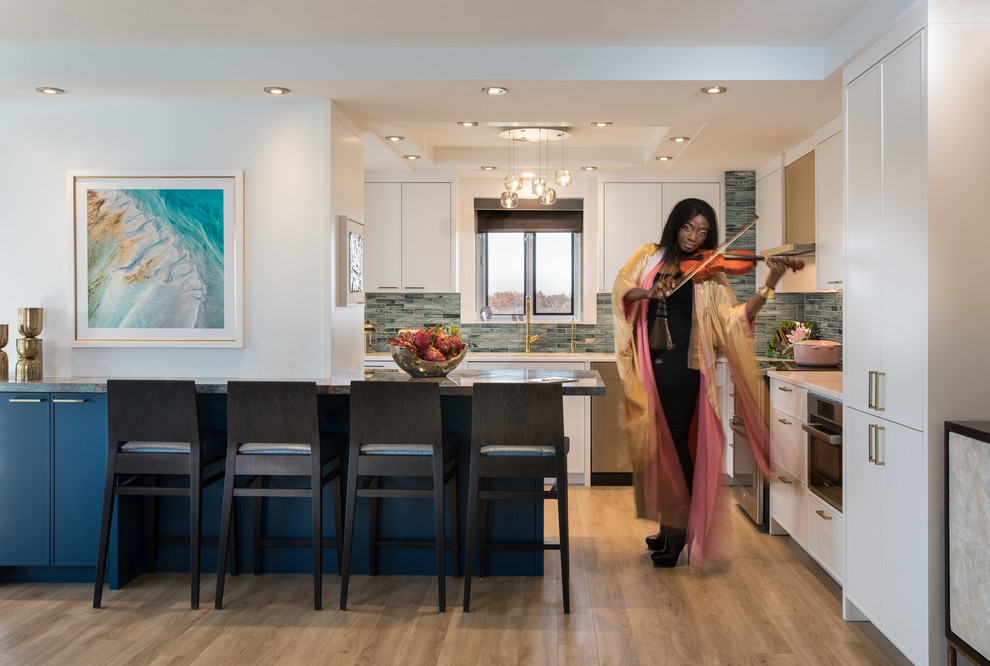Mid-sized modern l-shaped eat-in kitchen in Toronto with an undermount sink, shaker cabinets, white cabinets, marble benchtops, blue splashback, glass tile splashback, stainless steel appliances, vinyl floors, with island and blue benchtop.