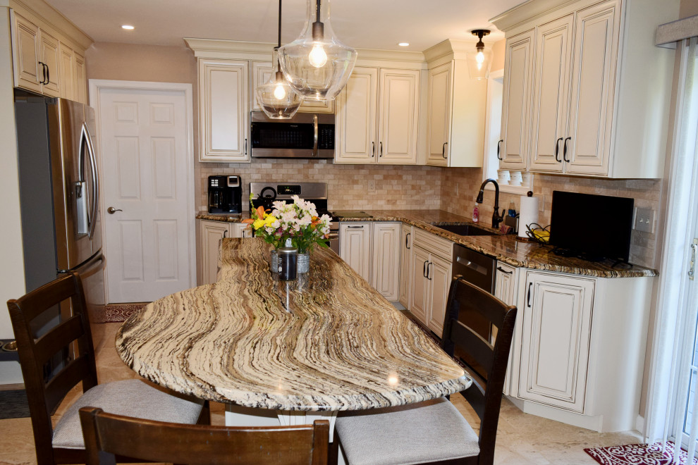 Example of a transitional porcelain tile kitchen design with an undermount sink, raised-panel cabinets, white cabinets, quartz countertops, beige backsplash, porcelain backsplash, stainless steel appliances and an island