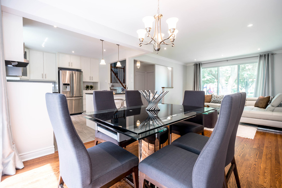 This is an example of a small modern dining room in Montreal with grey walls and medium hardwood floors.