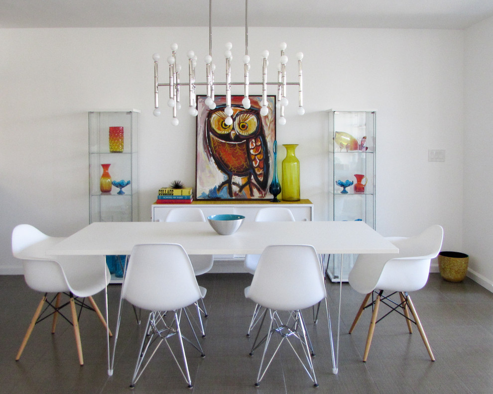 This is an example of a mid-sized midcentury dining room in Los Angeles with white walls, porcelain floors and no fireplace.