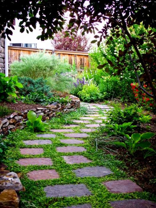 Inspiration for a small rustic shade side yard concrete paver retaining wall landscape in Denver.