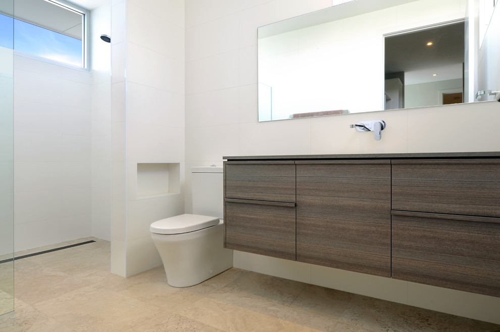 Mid-sized modern bathroom in Wollongong with an undermount sink, flat-panel cabinets, dark wood cabinets, engineered quartz benchtops, an open shower, a one-piece toilet, gray tile, stone tile, white walls and limestone floors.