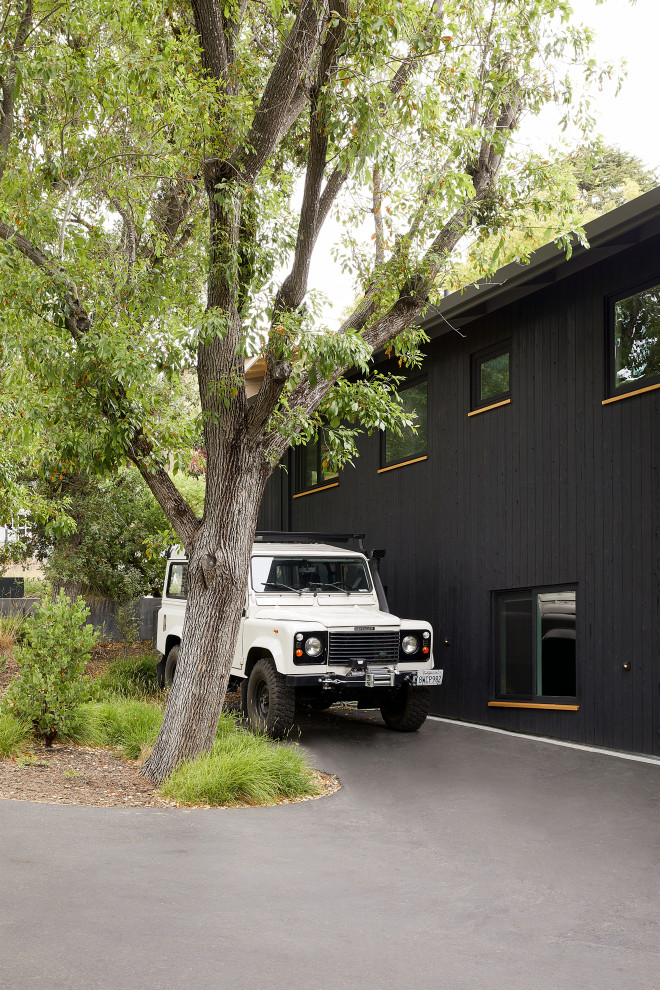 Inspiration pour une façade de maison noire vintage en bois à un étage.