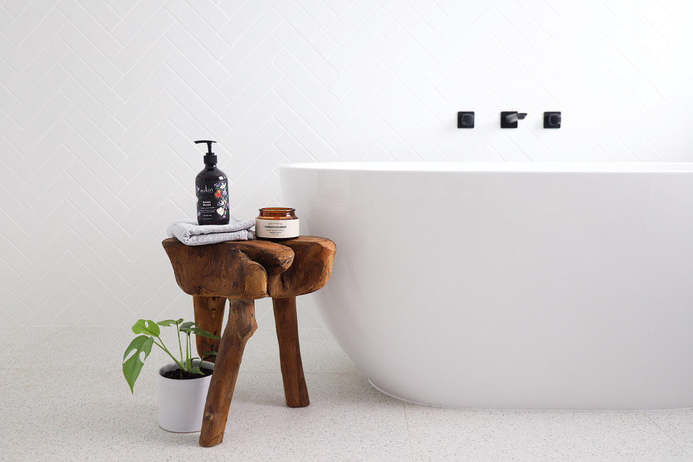 This is an example of a mid-sized transitional master bathroom in Perth with light wood cabinets, a freestanding tub, an open shower, a one-piece toilet, white tile, ceramic tile, white walls, ceramic floors, a vessel sink, engineered quartz benchtops, grey floor, an open shower, white benchtops, a double vanity and a floating vanity.