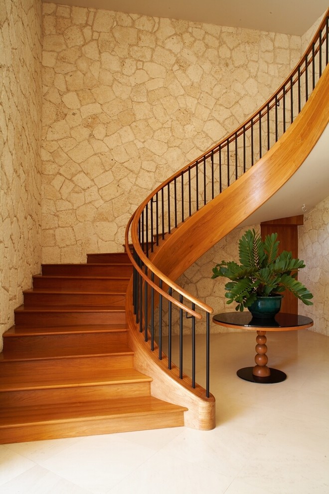 This is an example of a tropical wood curved staircase in Hawaii with wood risers.