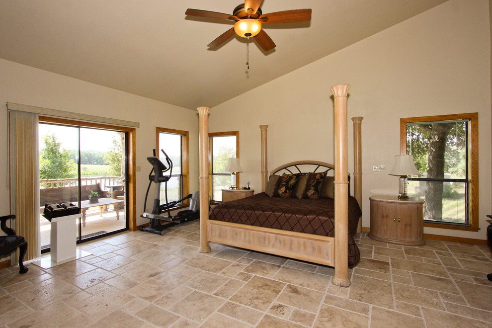 Inspiration for a large country master bedroom in Austin with white walls, travertine floors and no fireplace.