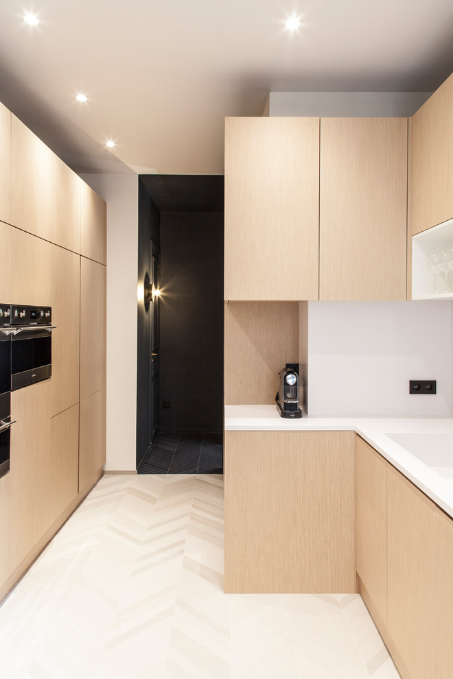 Inspiration for a mid-sized contemporary l-shaped eat-in kitchen in Paris with an integrated sink, beaded inset cabinets, light wood cabinets, quartzite benchtops, white splashback, engineered quartz splashback, panelled appliances, ceramic floors, no island, beige floor and white benchtop.