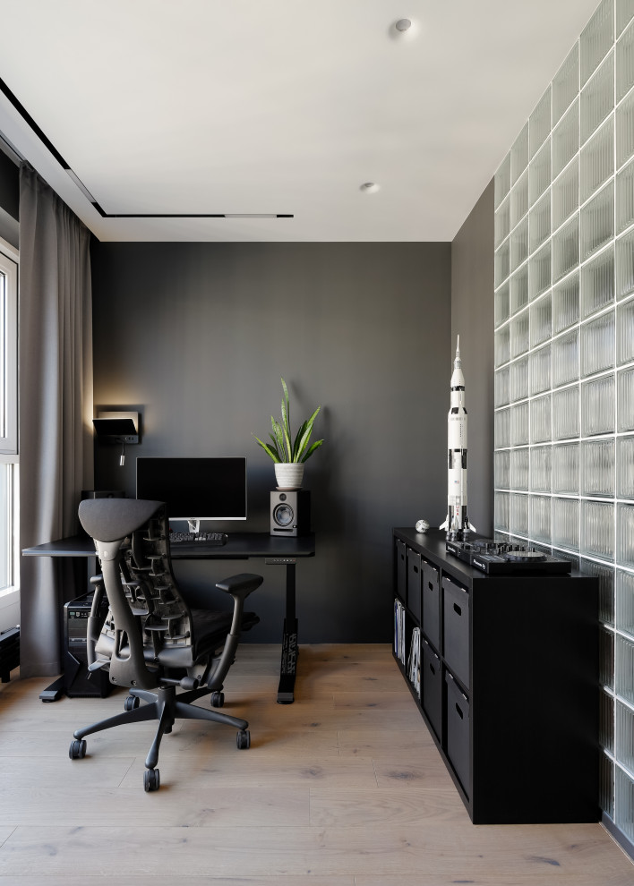 Immagine di un piccolo ufficio design con pareti grigie, parquet chiaro, scrivania autoportante e pavimento beige